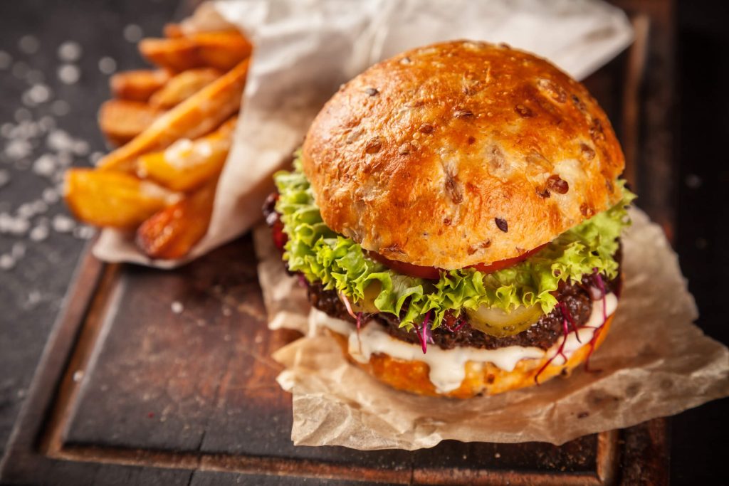 Fresh home-made hamburger served on wooded table with pomme fries